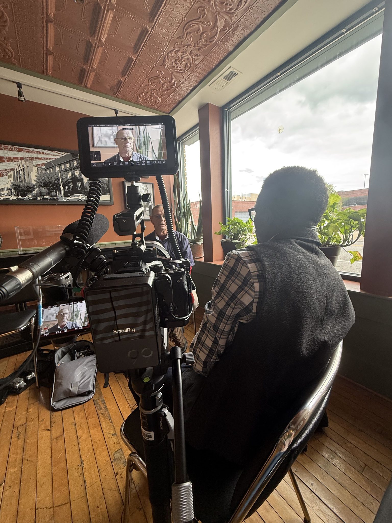 A camera rig framed against a bright window.